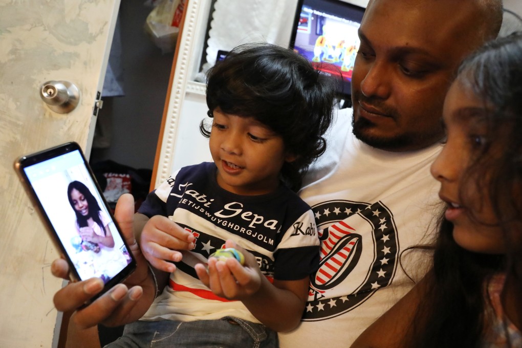 From left: Little Dinath, his dad Supun Thilina Kellapatha, and sister Sethumdi, make a video call to his half-sister Keana, 7, who is in Canada. Photo: Nora Tam