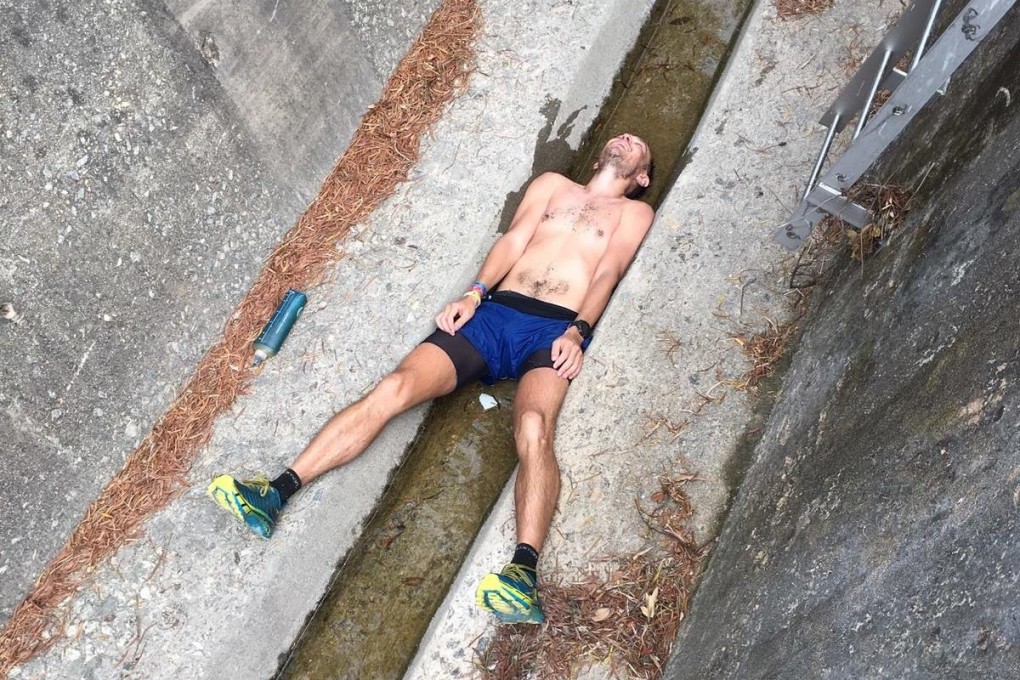 John Ellis squeezes into a catchwater during the Lantau Trail 70 trail race to cool down. Photo: Doug Treasure