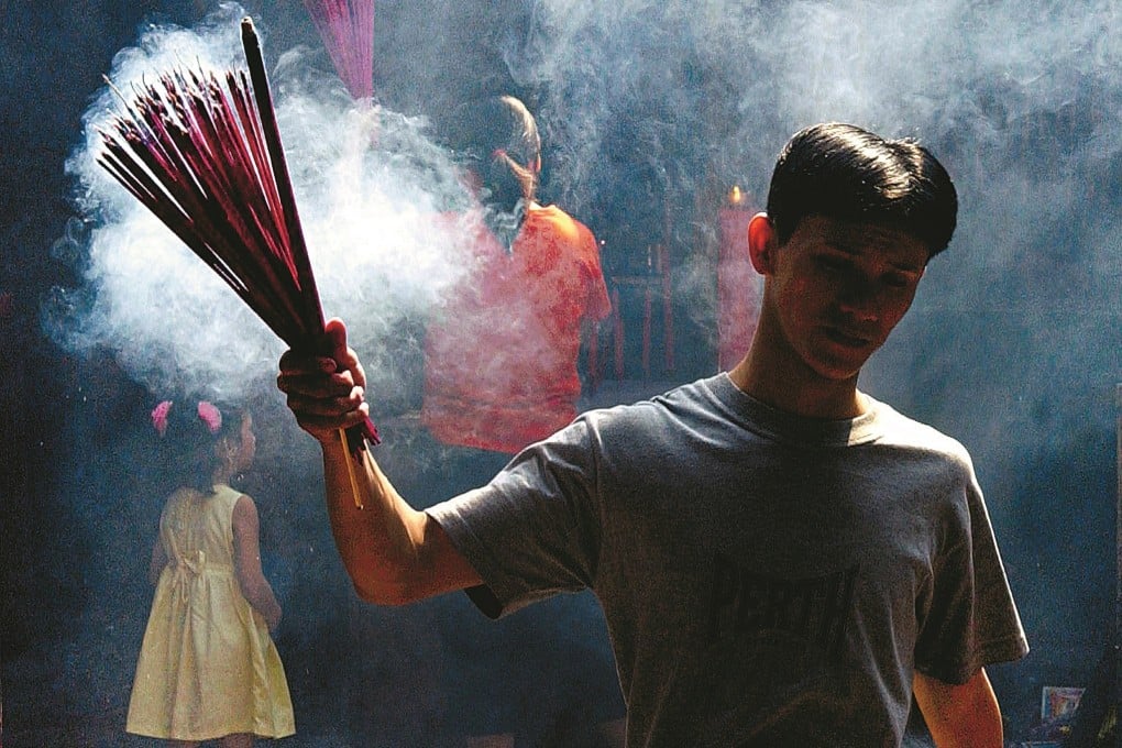 A Chinese Indonesian man offers incense as he prays at a temple in Jakarta’s Chinatown. Many who leave Indonesia for Taiwan struggle with their Chinese identity, and often still feel Indonesian. Photo: AFP