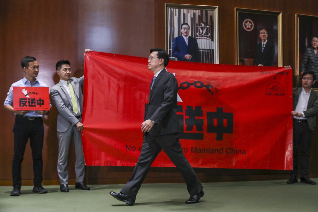 Secretary for Security John Lee walks past lawmakers protesting against the extradition bill at the Legislative Council building on May 22. Photo: Robert Ng