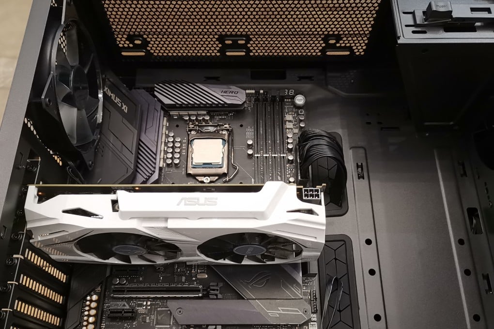 Building your own gaming PC involves choices about all the major components. Pictured is an Asus gaming motherboard with Intel CPU (no CPU cooler yet) in the centre, and four empty RAM slots on the right. You can also see a white graphics card with an Nvidia GPU installed.