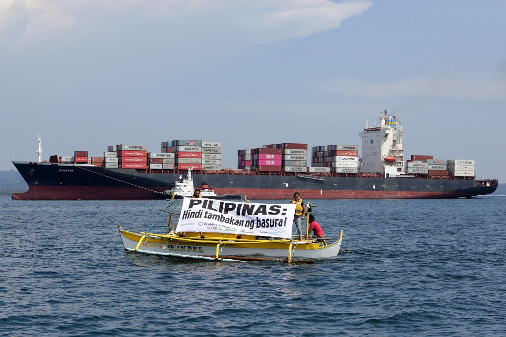 Environmental activists displaying a banner reading ‘Philippines is not a dumpsite’ next to the cargo ship MV Bavaria. Photo: EPA