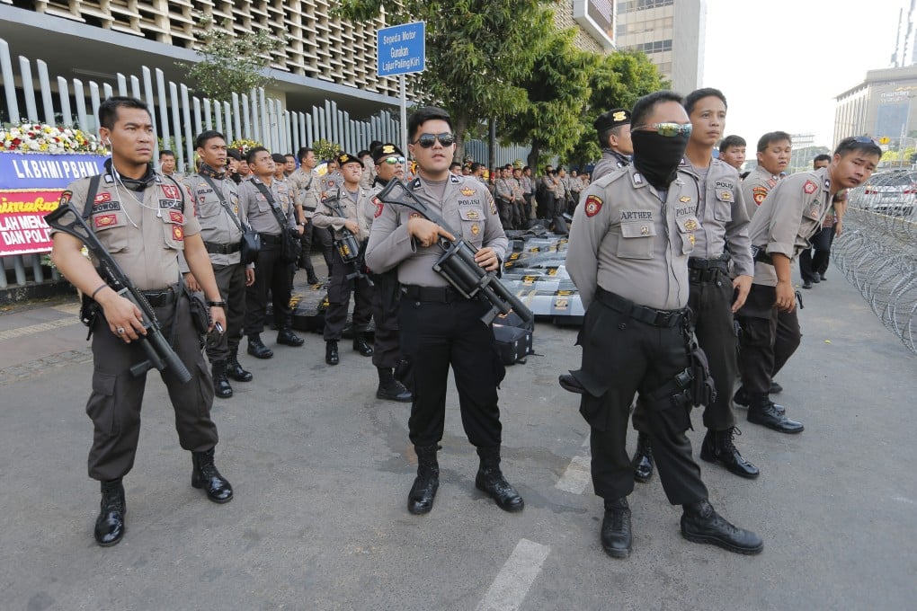 Riot police stand guard outside the General Election Supervisory Board building in Jakarta on May 28. Photo: AP