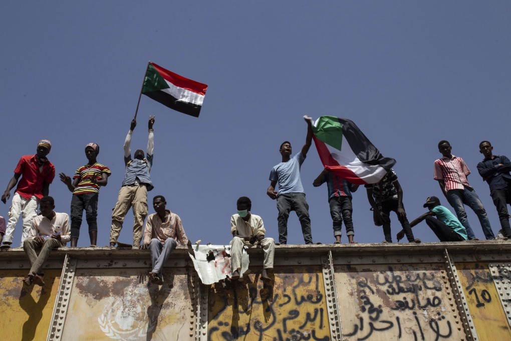 Sudanese protesters wave national flags at the sit-in outside the military headquarters, in Khartoum, Sudan. Photo: AP Photos