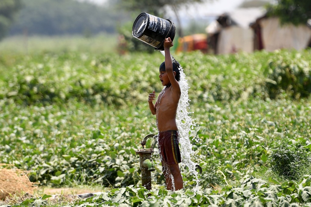 An Indian boy pours water on himself as he tries to cool himself off amid rising temperatures in New Delhi. Photo: AFP