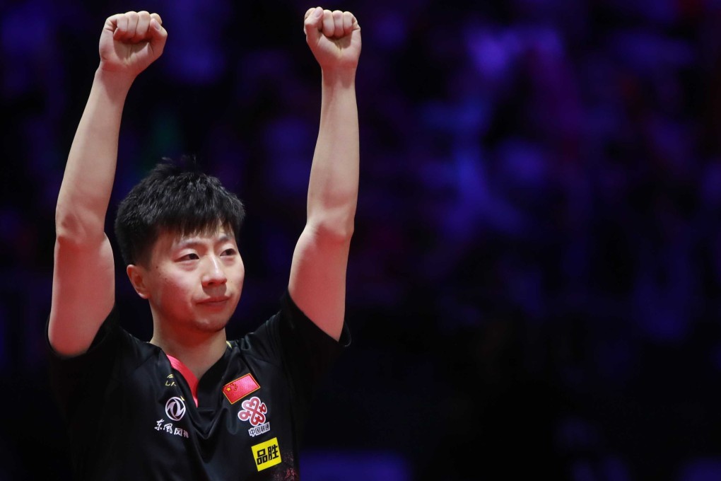 Ma Long holds both hands up after his victory. Photo: ITTF