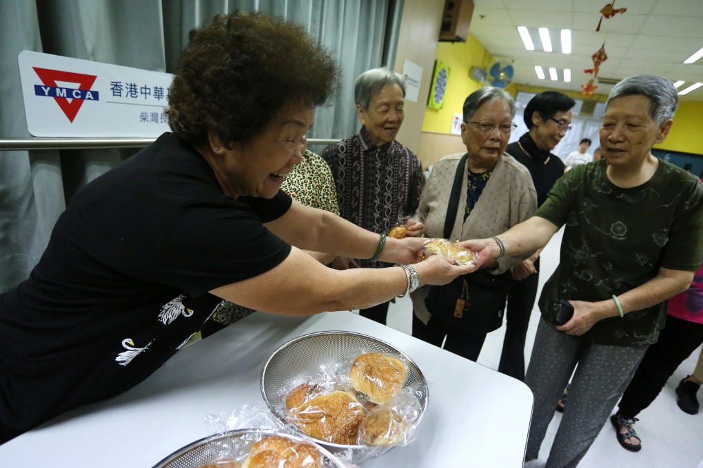 Yuen Pik-yuk hands out bread at Chai Wan Neighbourhood Elderly Centre. Photo: Jonathan Wong