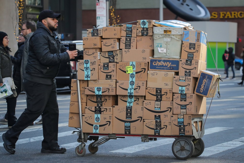 A delivery person pushes a cart full of Amazon boxes in New York on February 14, 2019. Photo: Reuters