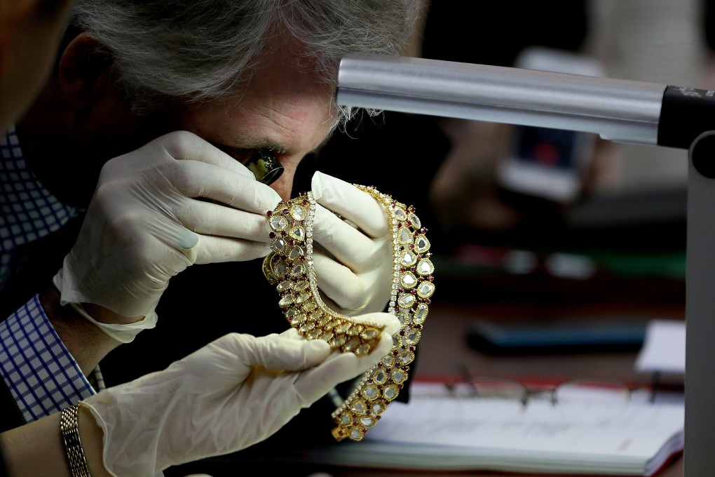 An appraiser from Christie's auction house inspects some of the jewellery that was seized. Photo: AP
