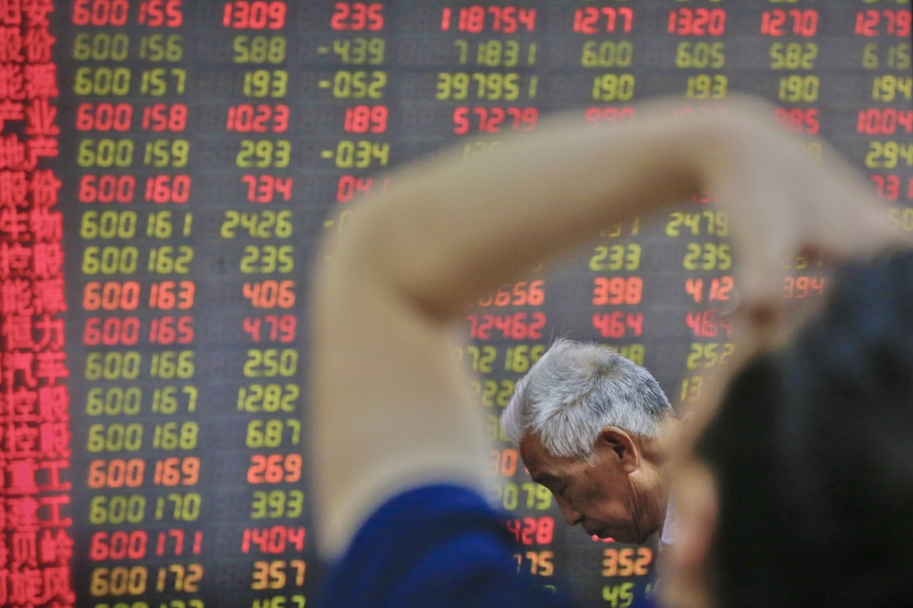 Chinese investors at a brokerage in Beijing on Tuesday, May 14, 2019. Contrary to global conventions, China uses green to represent losses and declines, and denotes advances and gains in red. Photo: AP
