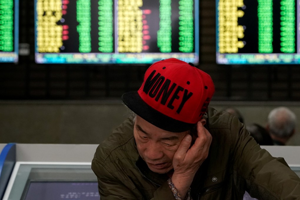 An investor looks at computer screens showing stock information at a brokerage house in Shanghai on May 6, 2019. Contrary to global conventions, China’s stock market denotes losses and declines in green, using red to represent gains and advances. Photo: Reuters