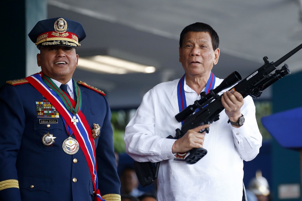 Philippine President Rodrigo Duterte, right, holds an Israeli-made Galil rifle presented to him by former police chief Ronald Dela Rosa. Photo: AP