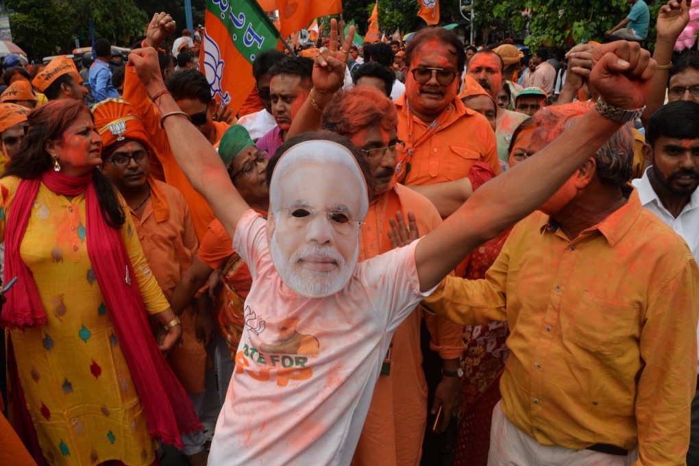 A supporter of the Bharatiya Janata Party wearing a mask of Indian Prime Minister Narendra Modi celebrates the win of a BJP candidate in Siliguri in northeast India on May 24 after the general election results were announced. Photo: AFP