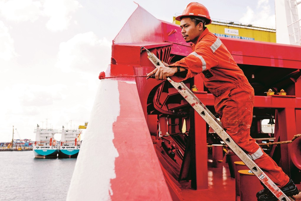 A Filipino seaman works on German cargo vessel MV Merwedijk in Hamburg harbour, Germany. Photo: Alamy