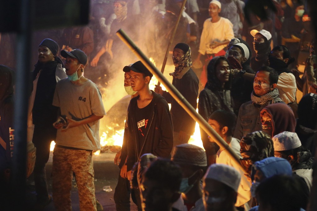 Supporters of defeated presidential candidate Prabowo Subianto stand near a fire during clashes with police in Jakarta on May 22. Photo: AP
