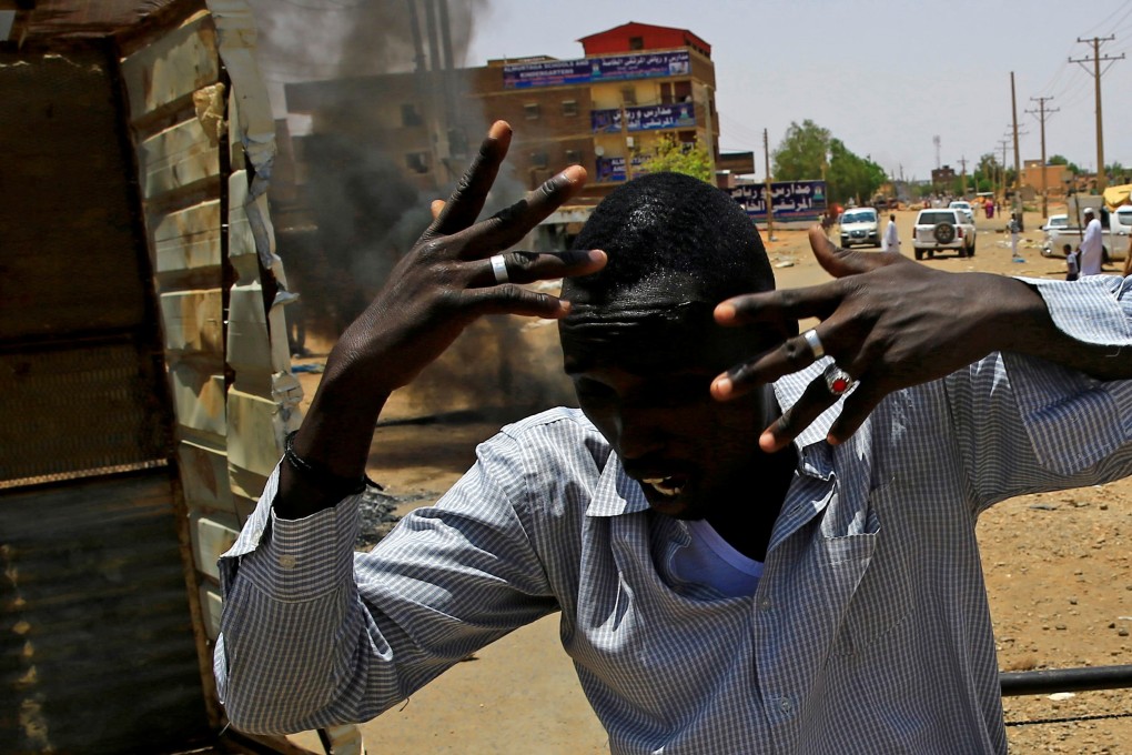 A Sudanese protester runs past a barricade in Khartoum. Photo: Reuters