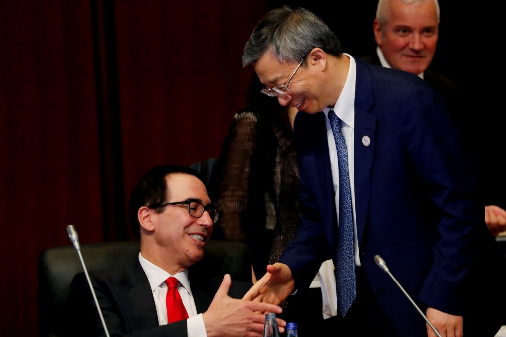 China’s central bank governor Yi Gang shakes hands with US Treasury Secretary Steven Mnuchin at the G20 meeting in Japan on Sunday. Photo: Reuters
