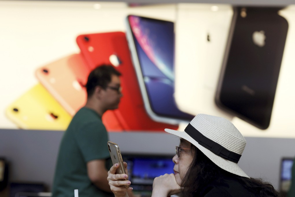 A customer looks at her iPhone at an Apple store in Beijing on May 10, 2019. Photo: AP