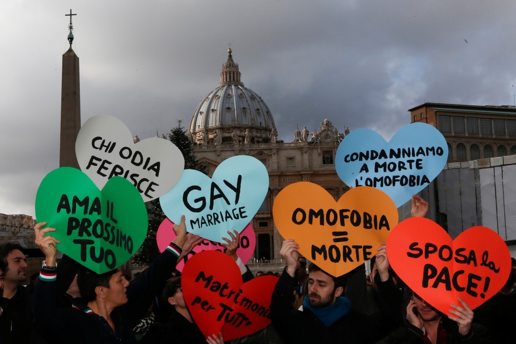 Protesters hold signs in front of St. Peter’s square at the Vatican in December 2012. Photo: Reuters