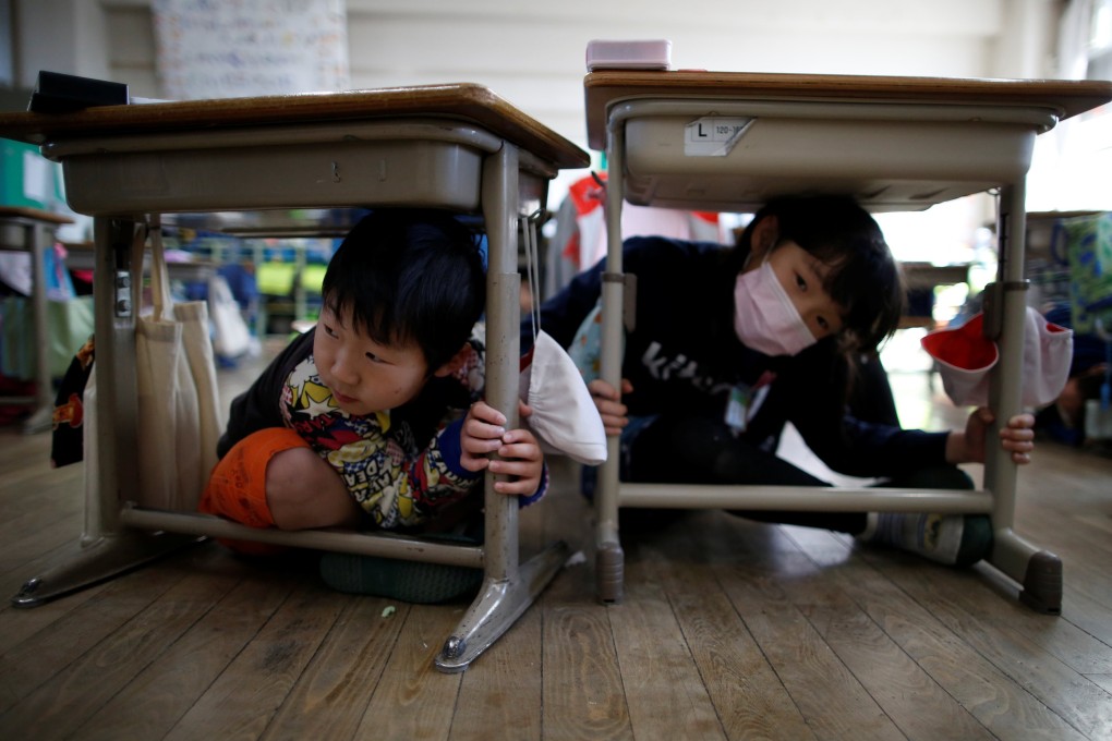 Tokyo schoolchildren take shelter under desks during an earthquake simulation exercise. Photo: Reuters