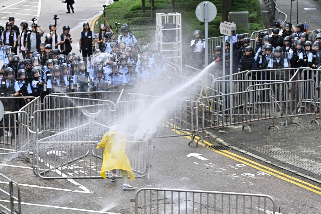 Police officers use a water canon on a lone protester near the government headquarters in Hong Kong on June 12, 2019. Photo: AFP