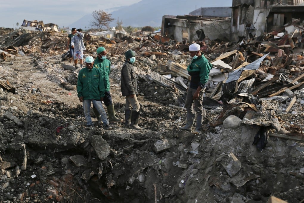 Volunteers of the humanitarian wing of the Islamic Defenders Front inspect earthquake damage in Palu in 2018. Photo: AP