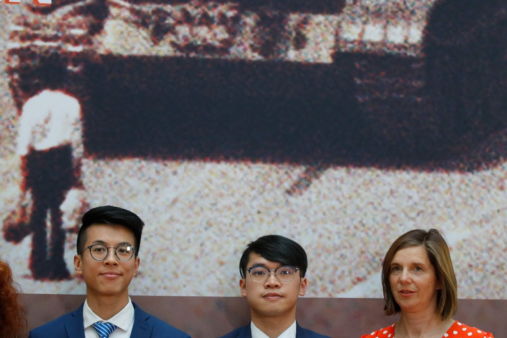 Ray Wong and Alan Li, two activists from Hong Kong who are under refugee protection in Germany, pose with politician Katrin Goering-Eckart at an event in Berlin on June 4, marking the 30th anniversary of the Tiananmen crackdown. In the background is the iconic “Tank Man” photo. Photo: AFP