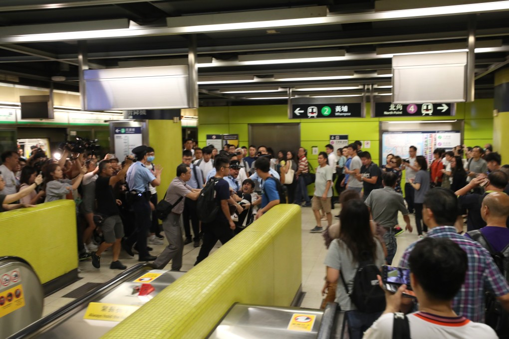 Police officers get to grips with a young passenger at Tiu Keng Leng station. Photo: Handout