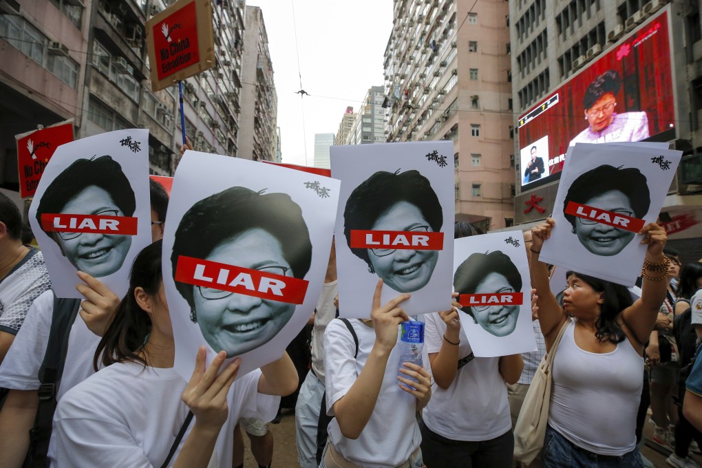 Protesters hold pictures of Hong Kong Chief Executive Carrie Lam as they march against the extradition bill from Causeway Bay to Admiralty on June 9. Photo: AP