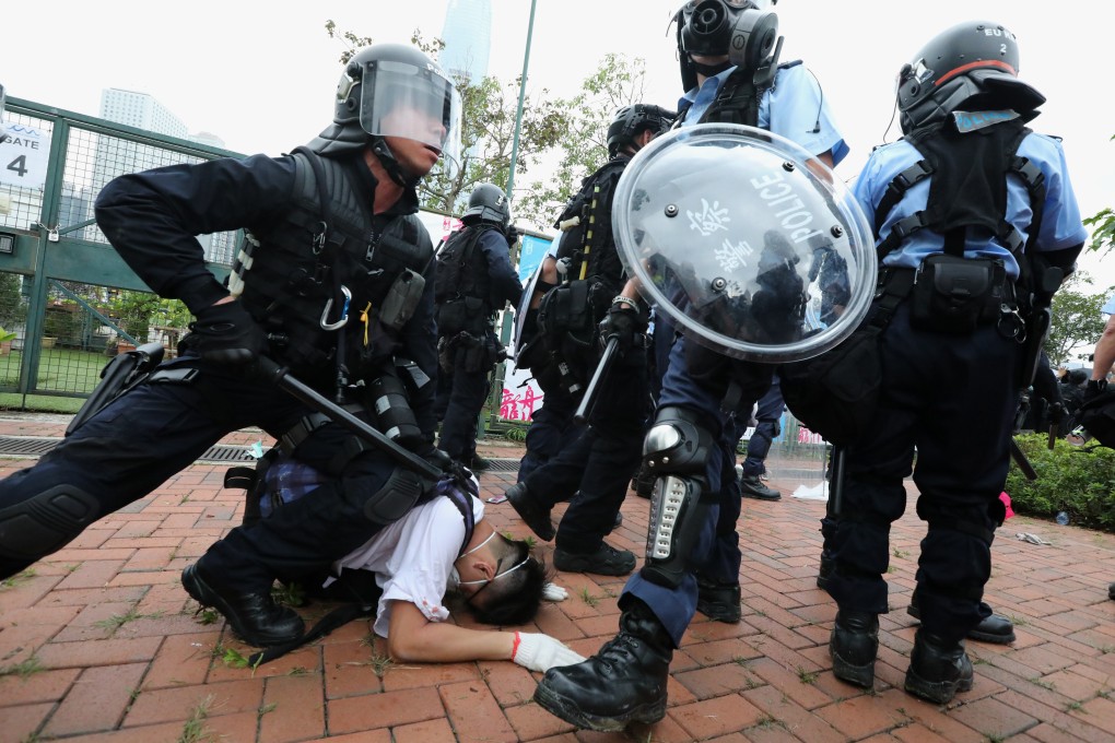 Police in full riot gear restrain a protester outside Legco on Wednesday. Photo: Felix Wong