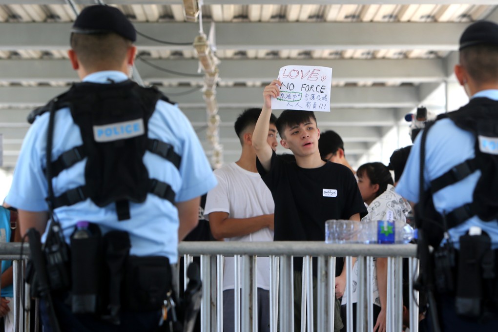 An anti-extradition protester on a footbridge in Admiralty holds up a poster saying “Love, No Force”, in response to police use of pepper spray, tear gas and rubber bullets on demonstrators earlier in the week. Photo: Winson Wong