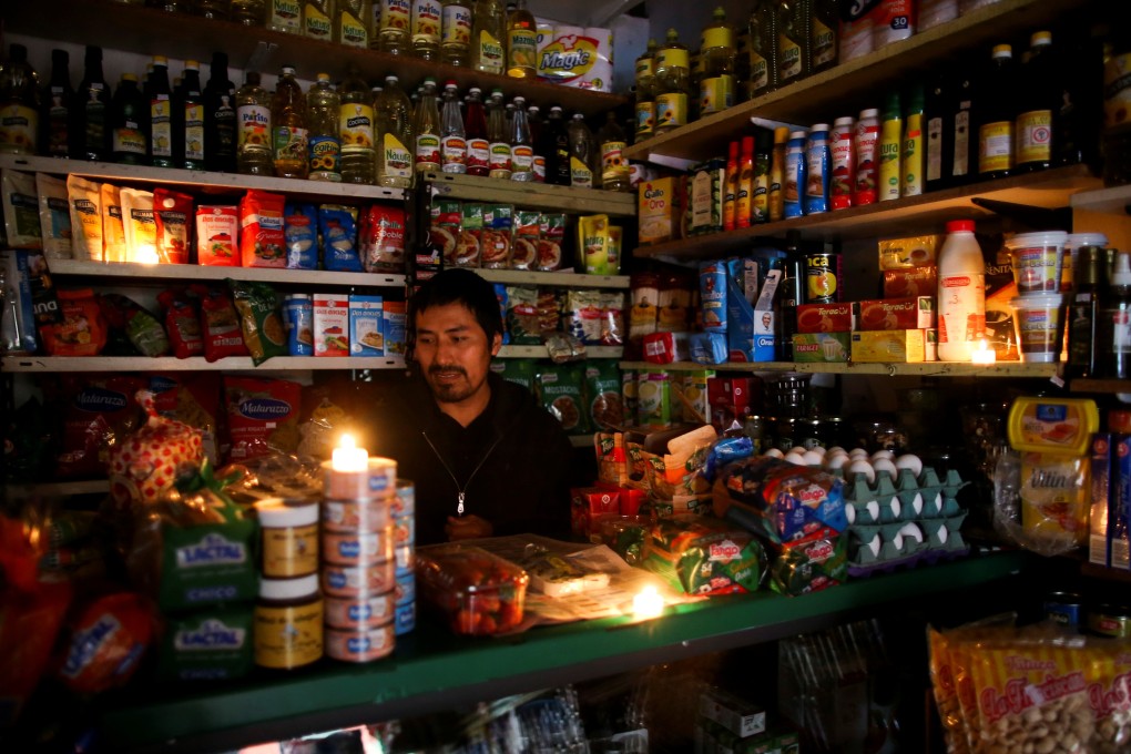 A vendor in Buenos Aires lights his store with candles during a national blackout in Argentina on Sunday. Photo: Reuters
