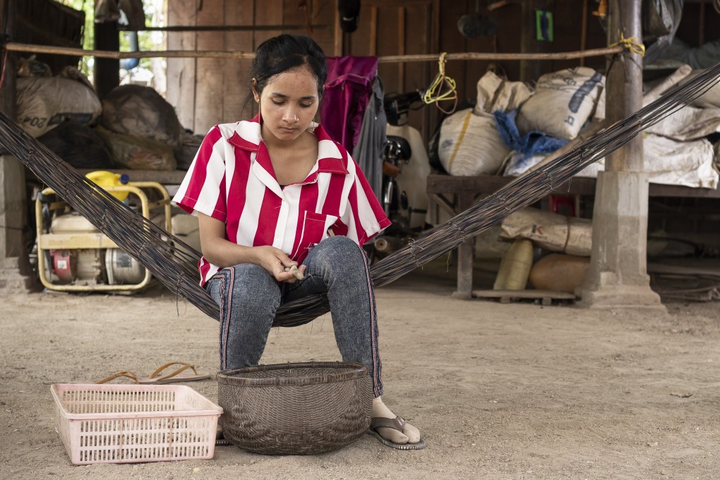 Lang Srey Sar, 19, peeling peanuts to be later sold. She was one of five Cambodian women who lost their left arms in a truck accident on the commute to their garment factories. Photo: Enric Català