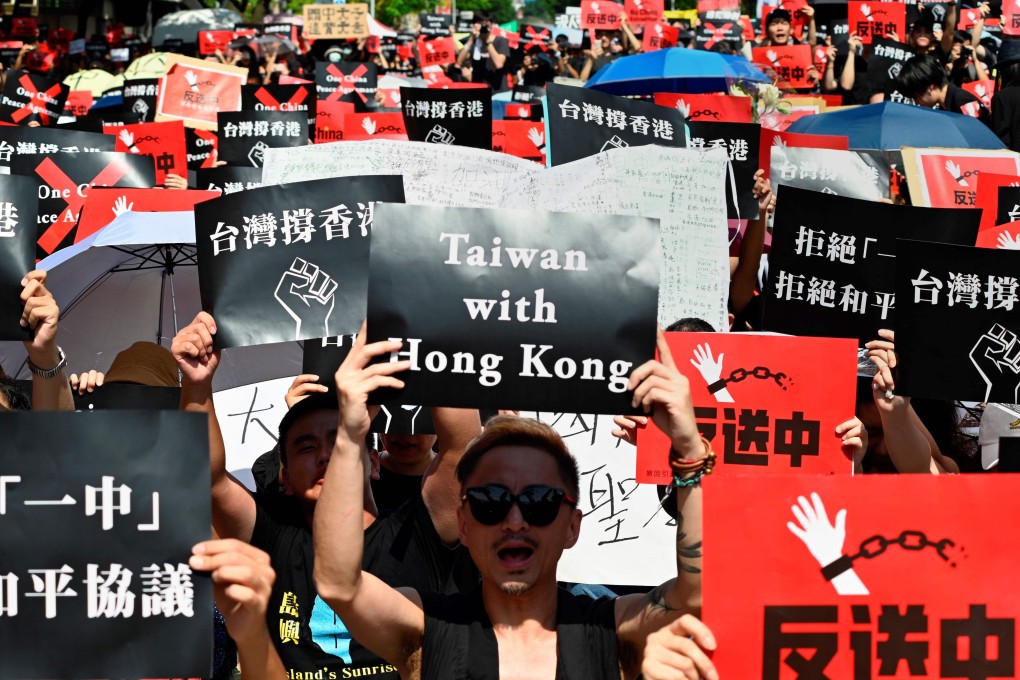 Protesters display placards during a demonstration in Taipei on June 16 in support of the protests in Hong Kong against the extradition bill that would allow the transfer of fugitives from Hong Kong to mainland China. Photo: AFP
