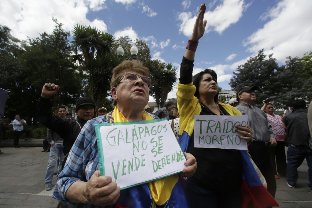A woman holds a sign that reads in Spanish ‘Galapagos is not to be sold, but to be defended’ during a protest against plans to allow the US military to use an island. Photo: AP
