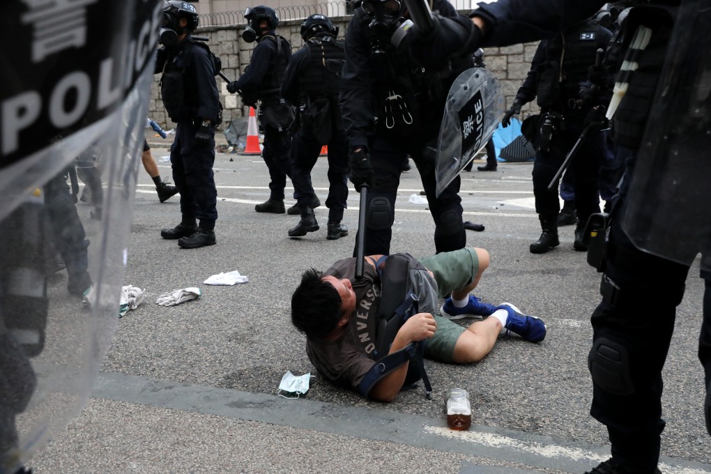 A police officer restrains a protester on Harcourt Road during clashes outside the Legislative Council Complex in Tamar. Photo: K.Y. Cheng