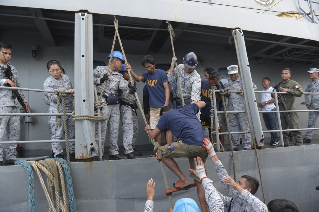 Rescued Filipino fishermen transfer to another ship on June 14 after the collision with a Chinese vessel five days earlier. Photo: AP