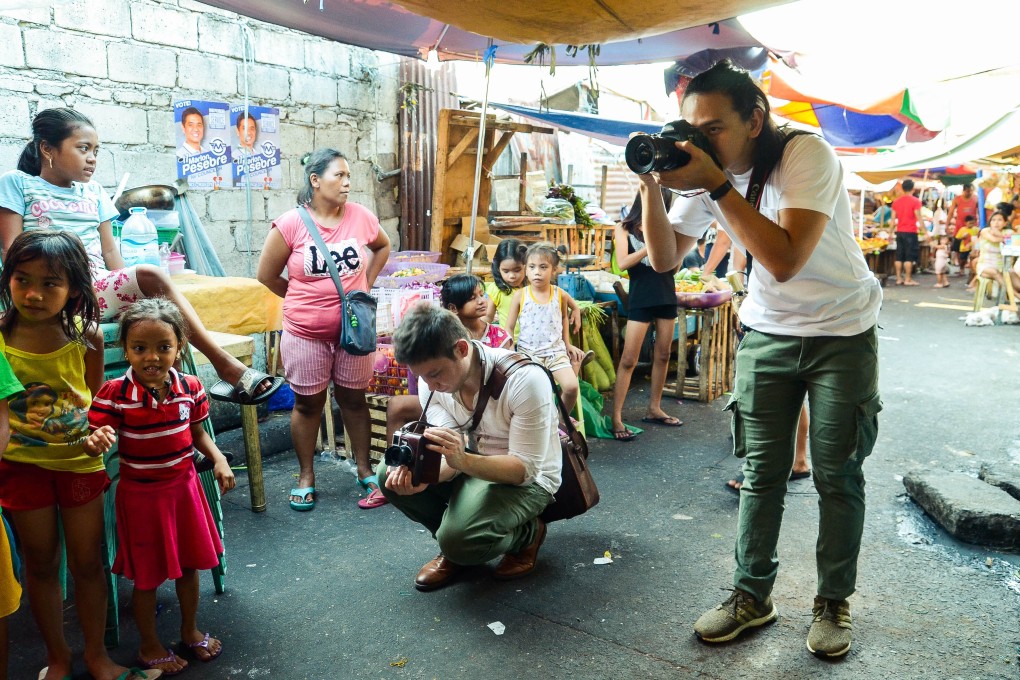 Not wanting to miss a moment, Jilson Tiu (right) and his companion, Jon Hodder, position themselves and begin shooting the ongoing game of pukpok palayok. Photo: Maro Enriquez