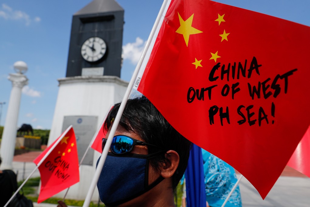 A Filipino activist holds a paper Chinese national flag during a protest in Manila against the sinking of the fishing boat. Photo: EPA