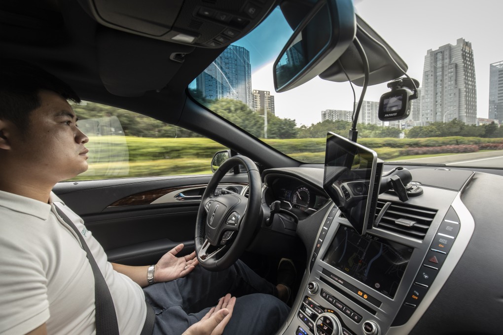An employee sits behind the steering wheel of a Pony.ai autonomous vehicle as it travels along a road during a demonstration in the Nansha district of Guangzhou, Guangdong Province, China, on Wednesday, April 10, 2019. Photo: Bloomberg