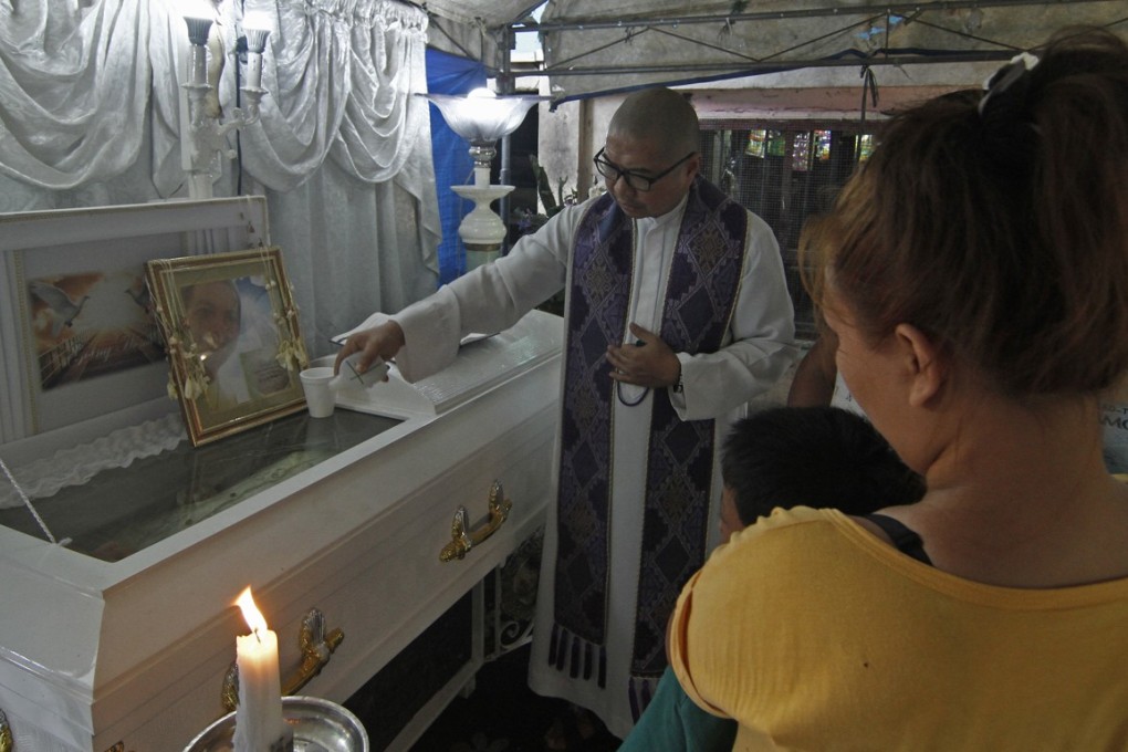 Fr. Flavie Villanueva, SVD, blesses the casket of 34 year old Jerito Garganta after he was shot and killed by unknown assailants along Kawal St., district 28, Caloocan City on the night of May 6, 2019. Photo: Vincent Go