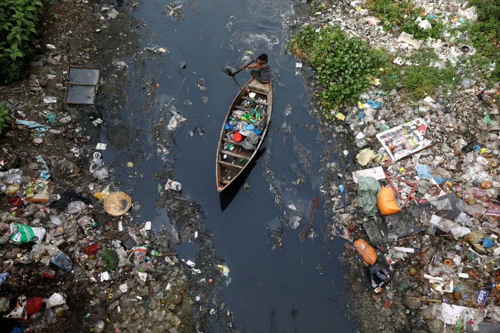 Collecting plastic material from dirty water in Dhaka, Bangladesh, in April. Photo: Reuters