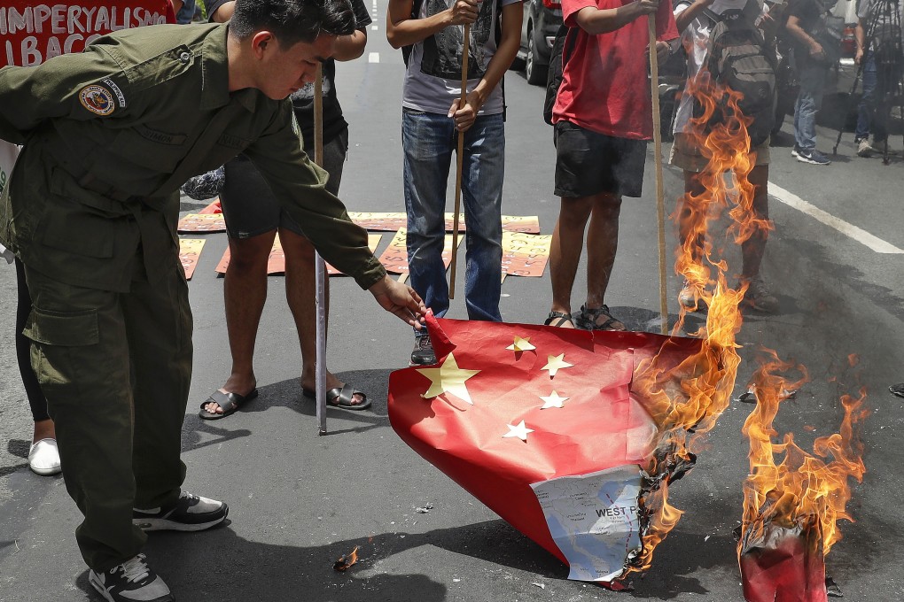 Protesters burn a mock Chinese national flag after a Filipino fishing boat was sunk in the disputed South China Sea when it was hit by a Chinese vessel, which then abandoned the 22 Filipino crewmen. Photo: AP