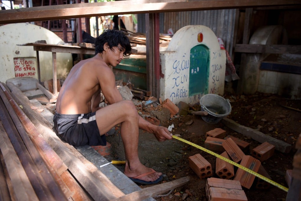 A man preparing the foundation to build a house above graves in Phnom Penh. Photo: AFP