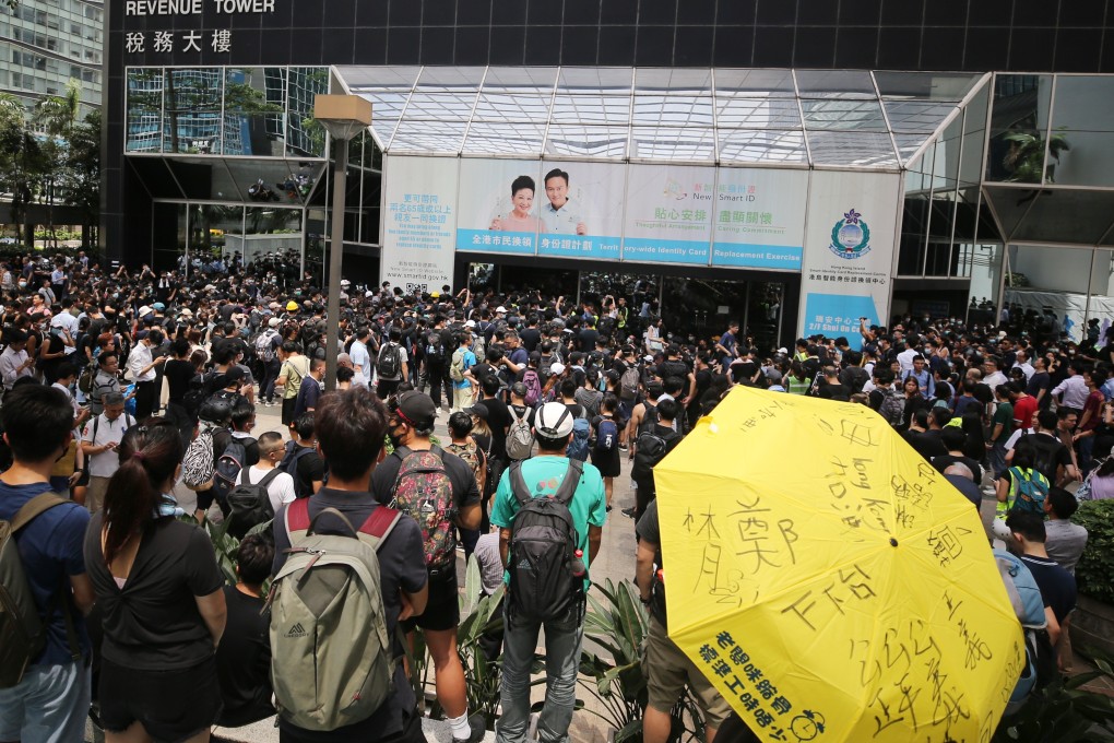 A crowd gathers outside Revenue Tower in Wan Chai, just one of the spots occupied on Friday during the rolling protests. Photo: Winson Wong