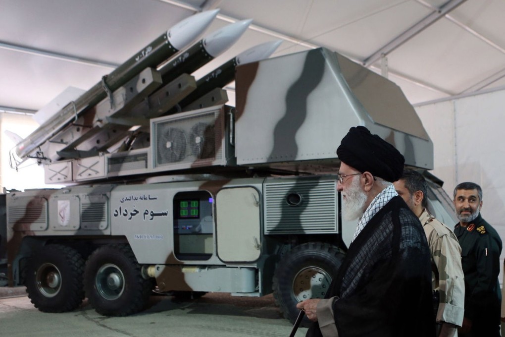 Iranian Supreme Leader Ali Khamenei stands next to a missile system in this handout picture from 2014. Photo: EPA