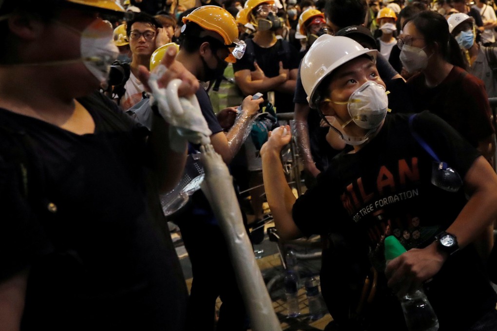 A protester throws an egg into the wall of the police headquarters in Wan Chai. Photo: Reuters