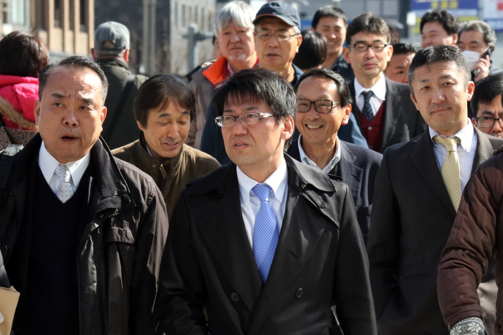 Japanese businessmen cross a road in Tokyo. Reports of abuse against men by their female partners have skyrocketed in Japan. Photo: AFP