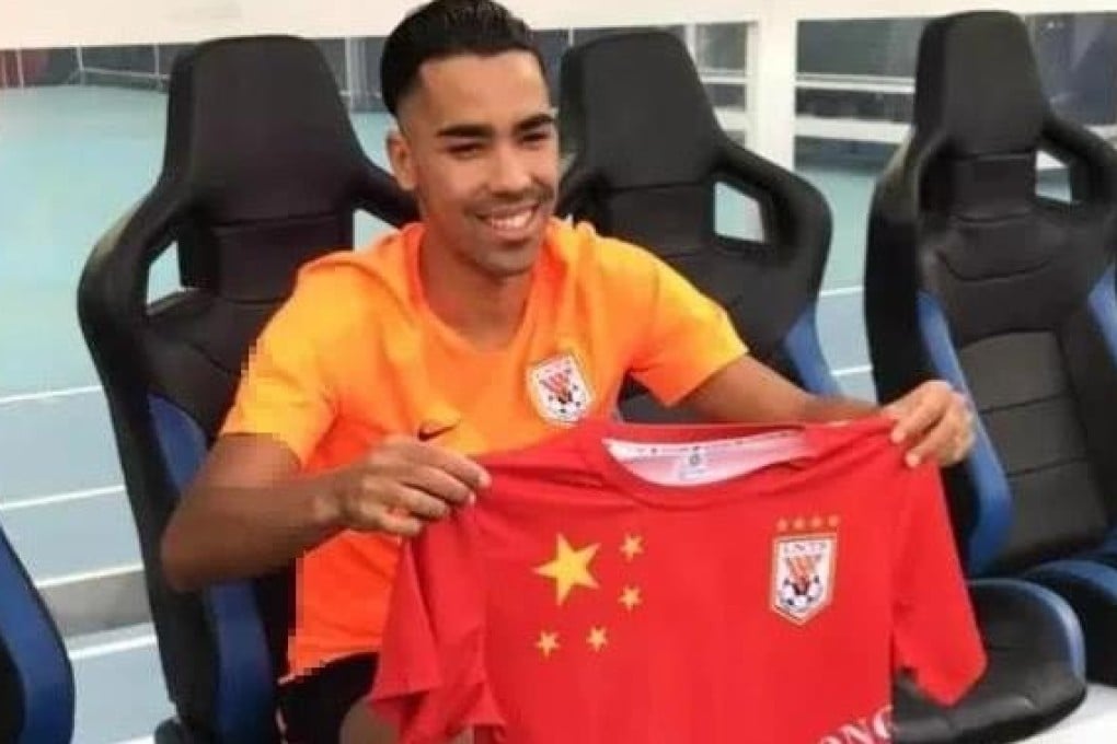 Pedro Delgado holds a shirt featuring the Chinese Super League side Shandong Luneng's badge and the China flag. Photo: Sina Sports