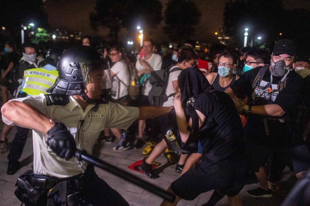 A police officer tries to restrain a protester during a clash outside the Legislative Council in the early morning of June 10, following a massive rally against the proposed extradition law. Photo: AFP